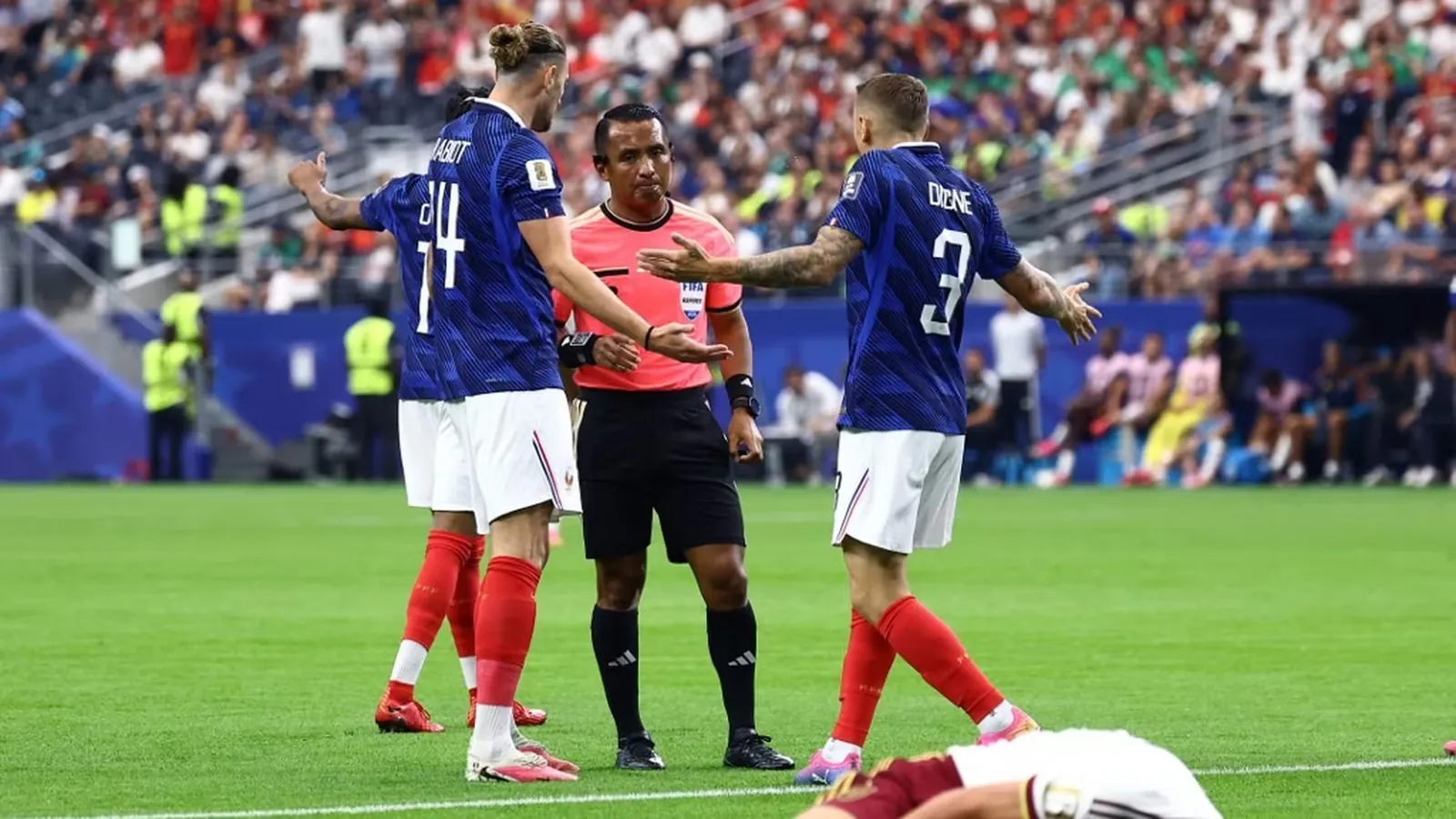 L'arbitre Ivan Barton &eacute;change avec Adrien Rabiot et Lucas Digne lors de France-Espagne, mardi 14 juillet, en demi-finale de la Coupe du monde 2026. (CHARLY TRIBALLEAU / AFP)